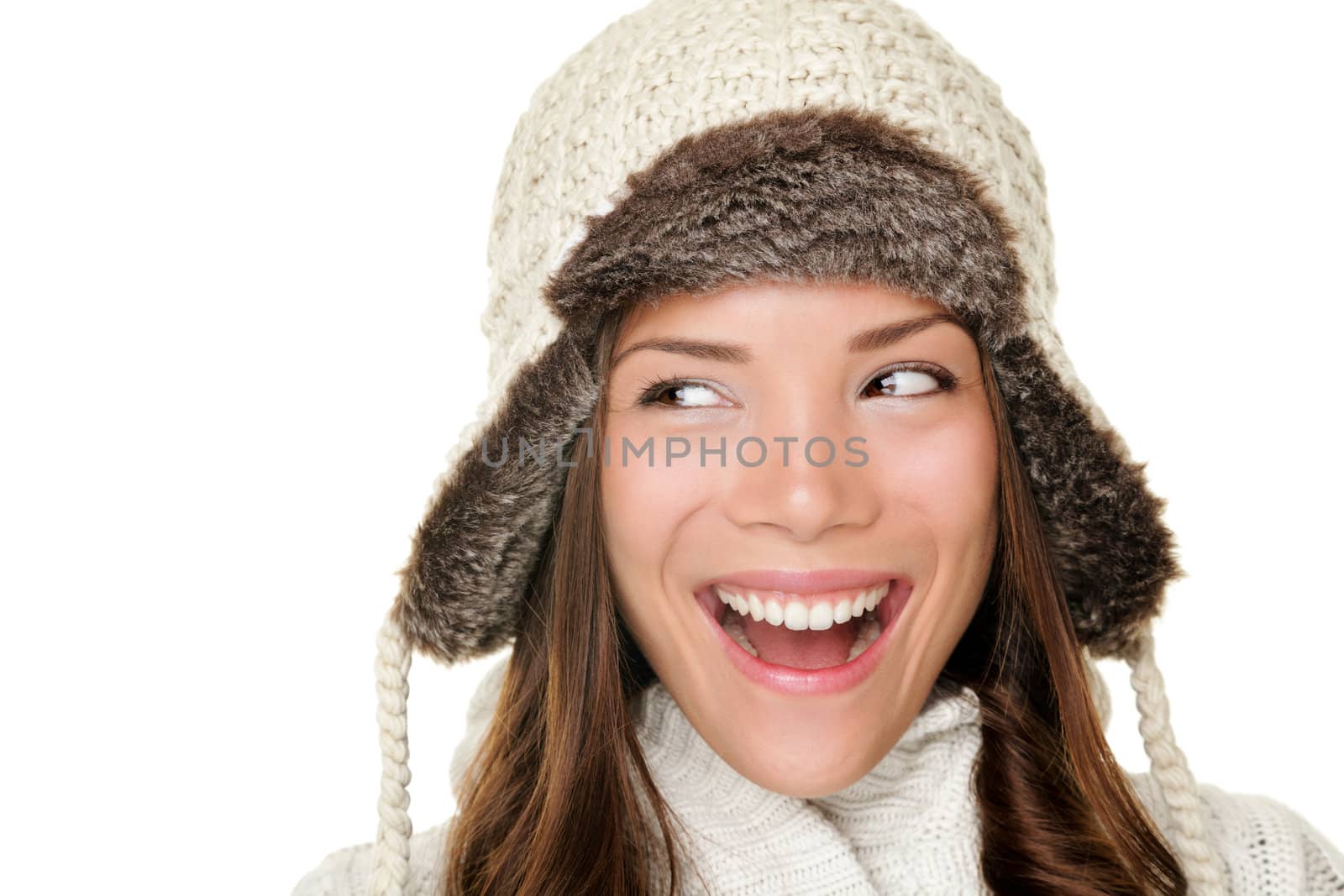 Winter woman looking sideways happy isolated on white background. Closeup portrait of beautiful winter girl wearing warm clothes and winter hat looking to the side. Chinese Asian / Caucasian female model.