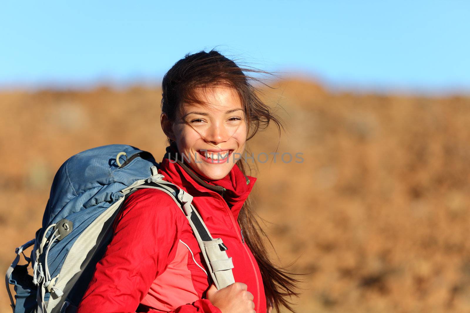 Healthy lifestyle woman hiker smiling happy outside on hiking trip. Beautiful natural candid smile on mixed race Caucasian / Asian female hiker outdoors in nature.