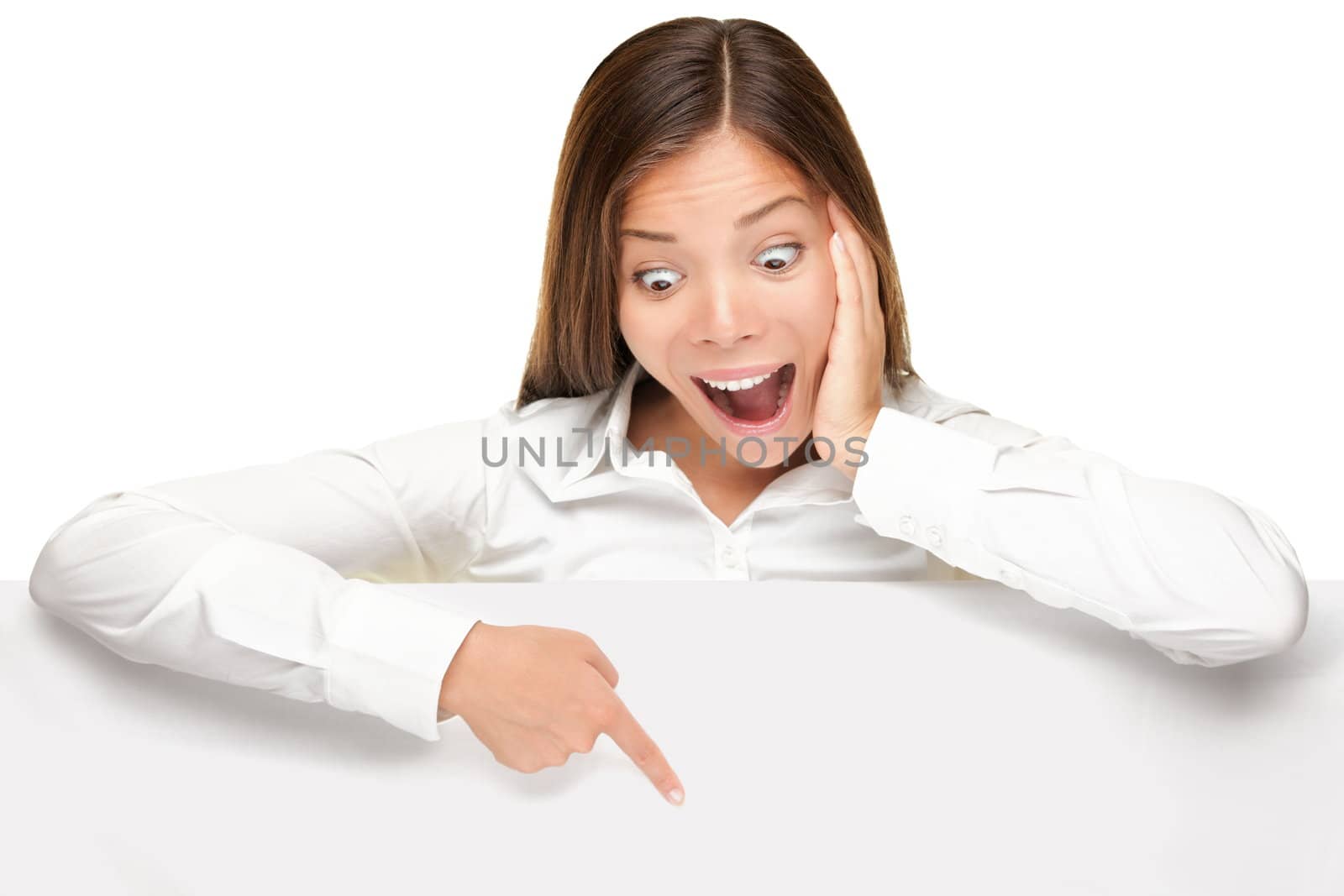 advertising banner sign - woman excited pointing looking down on empty blank billboard paper sign board. Young business woman isolated on white background.