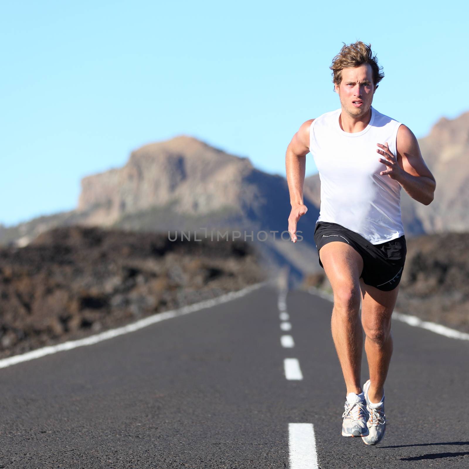 Runner running for Marathon on road in beautiful mountain landscape. Caucasian man jogging outdoors in nature.
