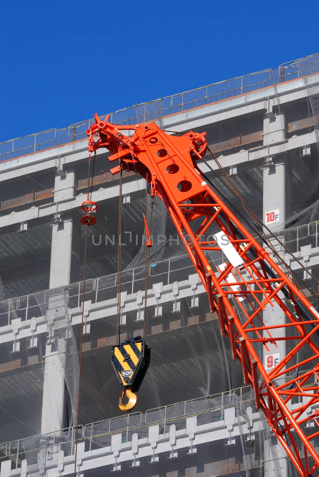 construction site with rising up building and red crane foreground