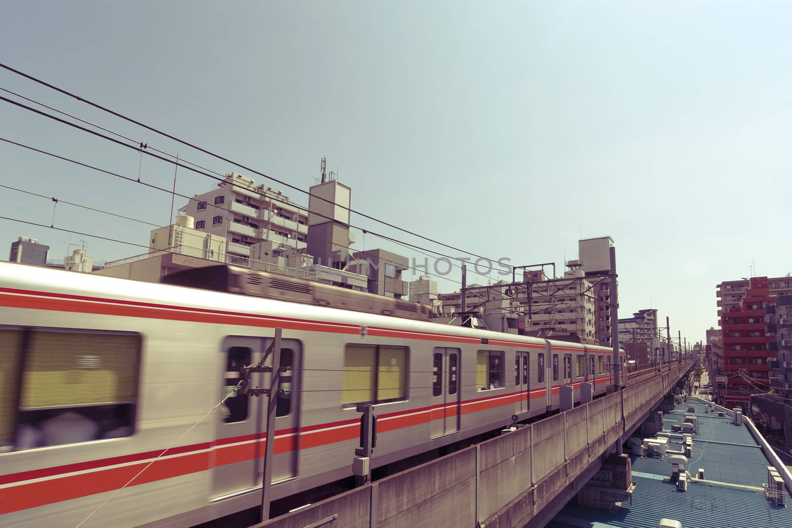 rapid train moves between Tokyo buildings by hanged up railway road