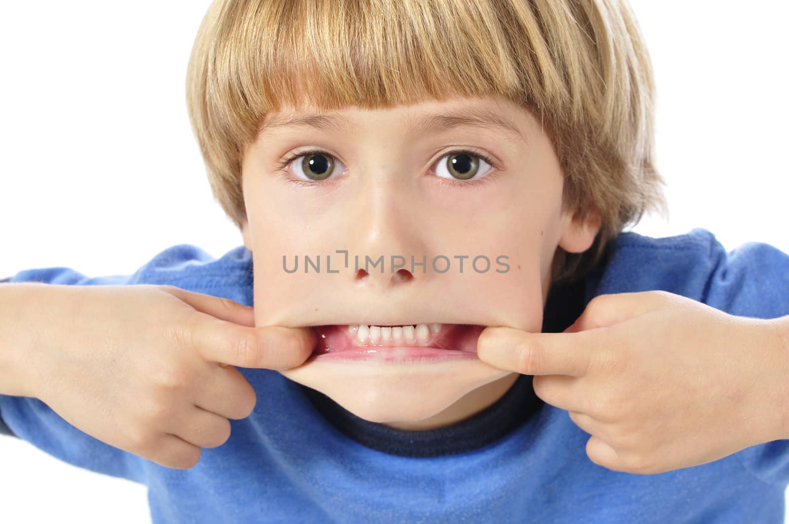 Young child making funny face by pulling mouth open shows bottom teeth