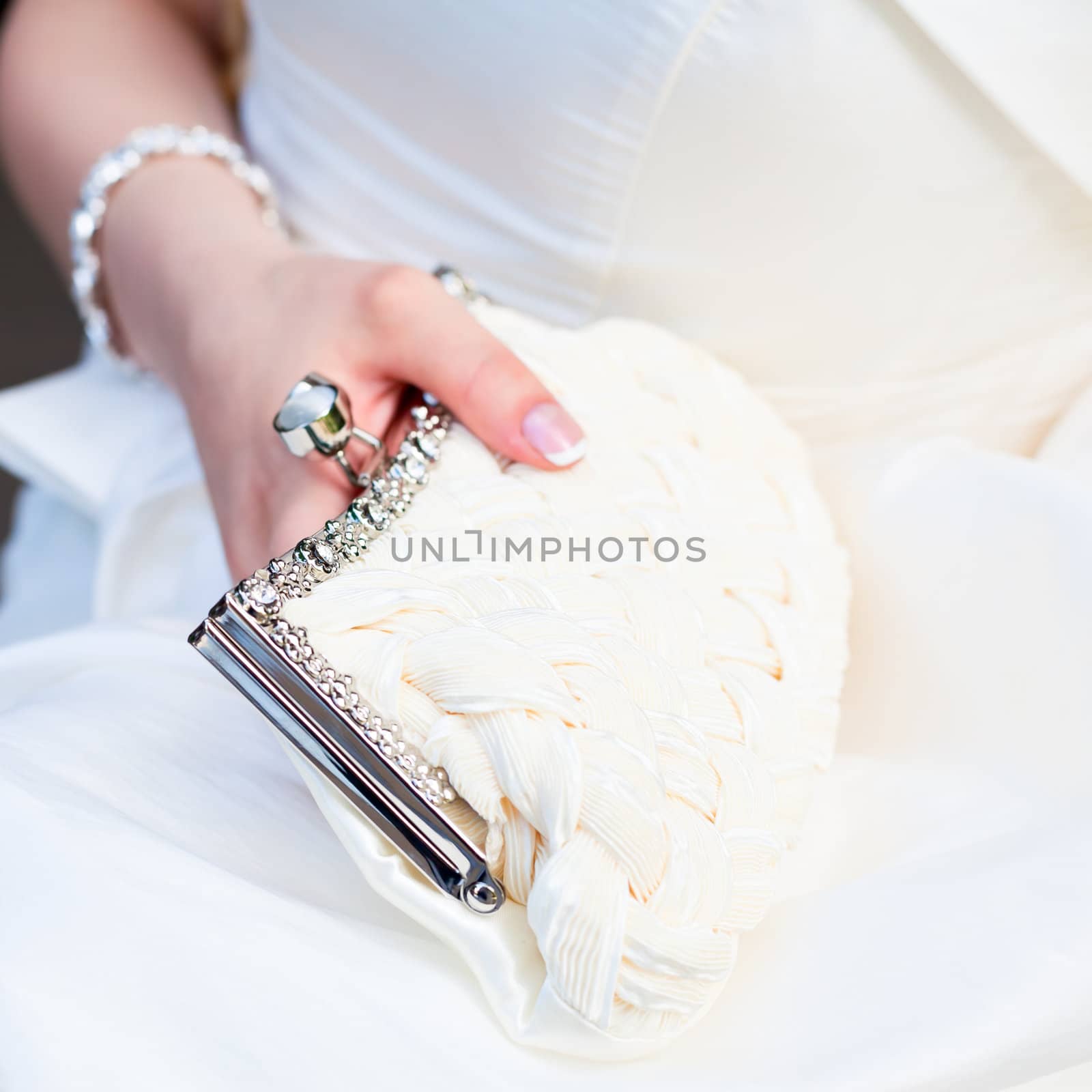Bride holding white pouch close-up