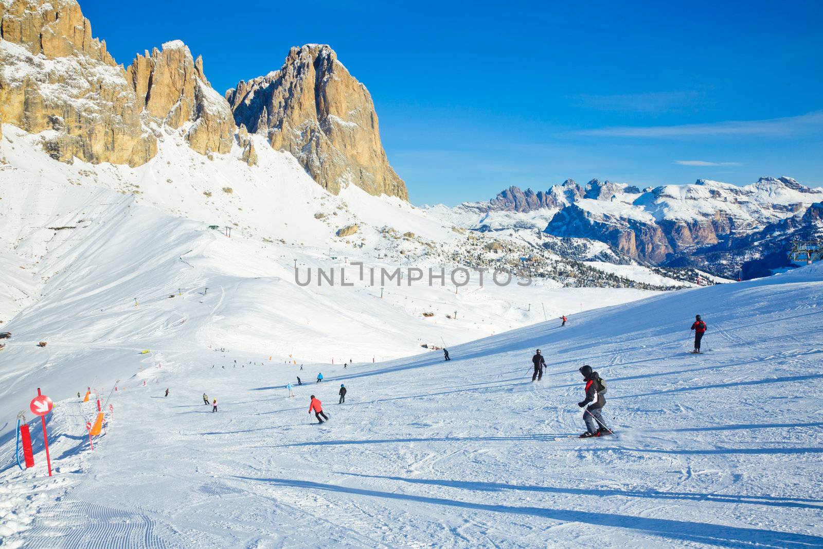 Skiers going down the slope at Val Di Fassa ski resort in Italy