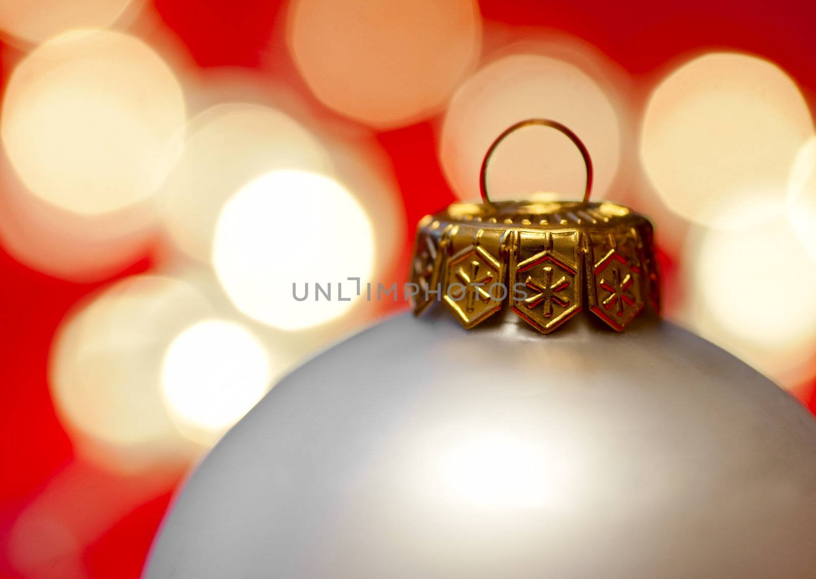 White Christmas bauble with blured lights in background, very shallow DOF