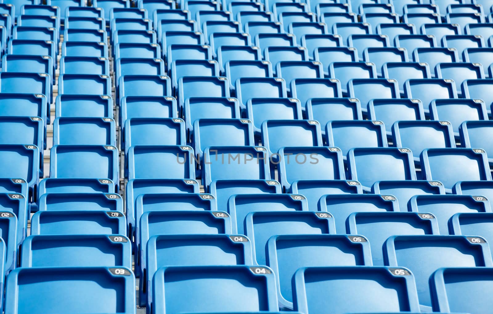 Folded blue plastic chairs on a temporary tribune