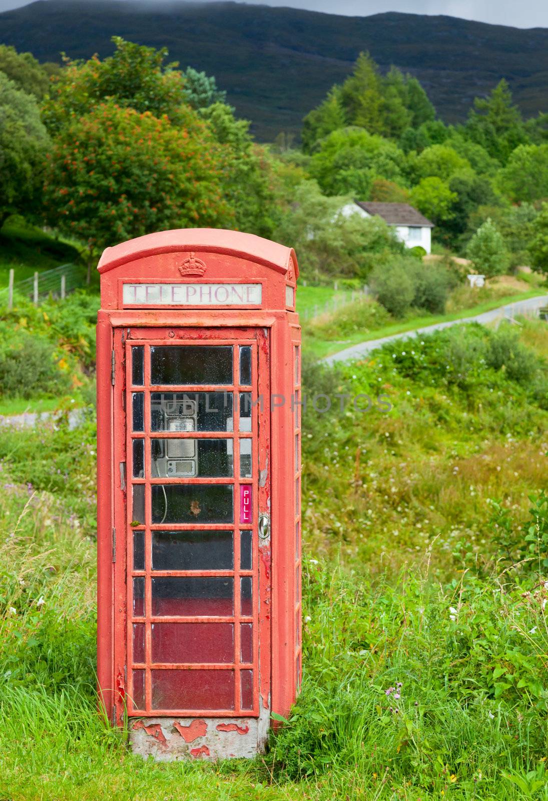 Old weathered red telephone kiosk in Scotland
