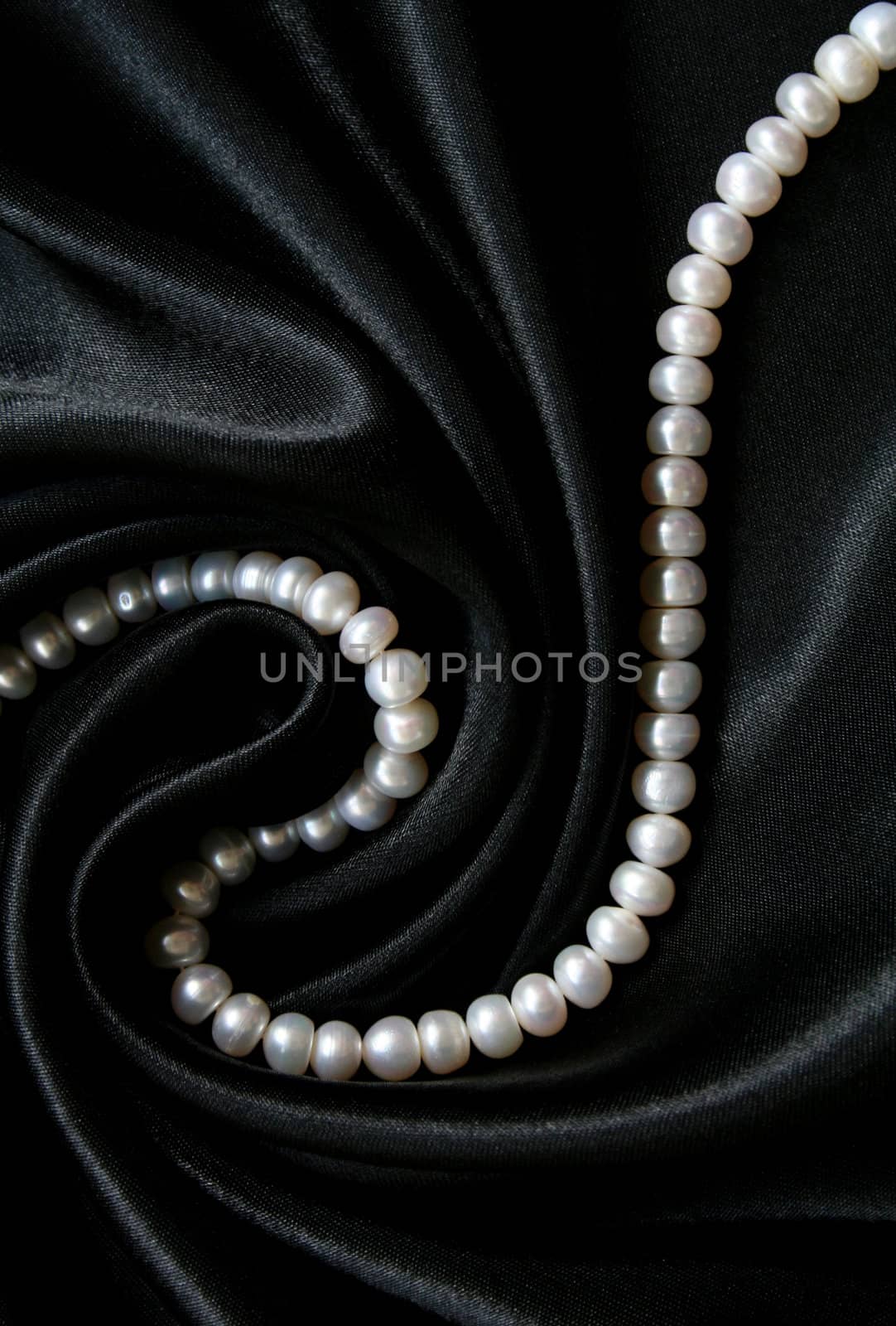 White pearls on the black silk can use as background
