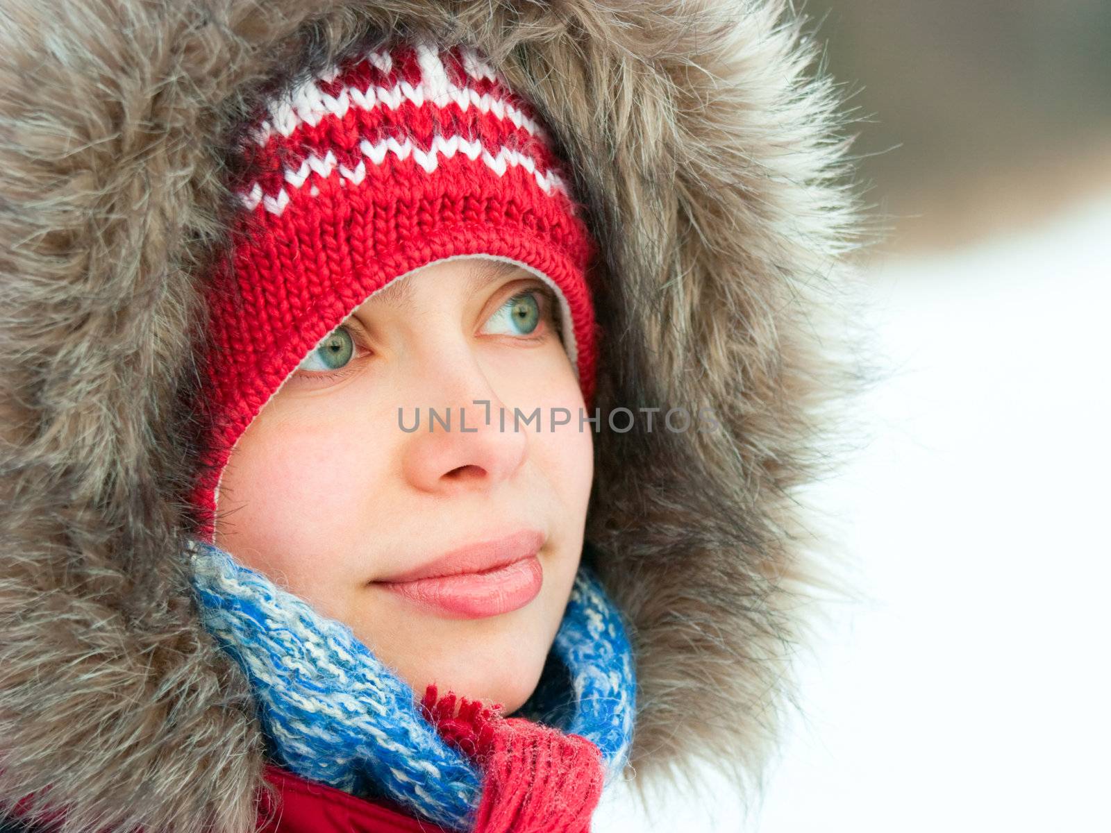 Young woman wearing furry hood and winter hat