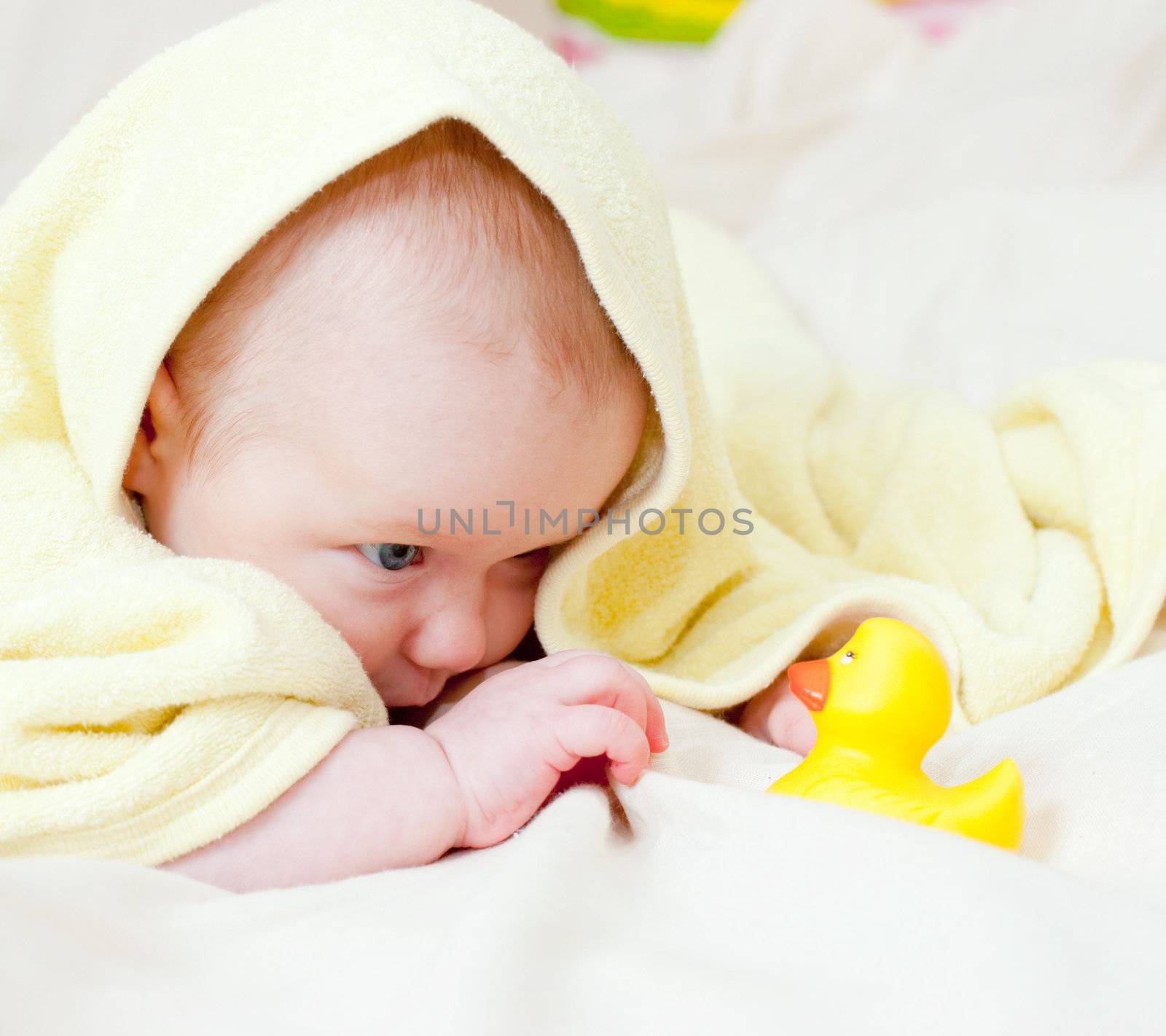 Infant playing with rubber duck by naumoid