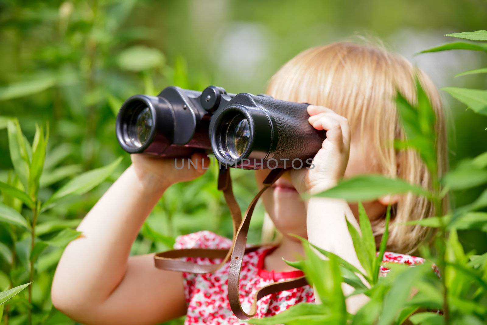 Little girl looking through binoculars outdoor