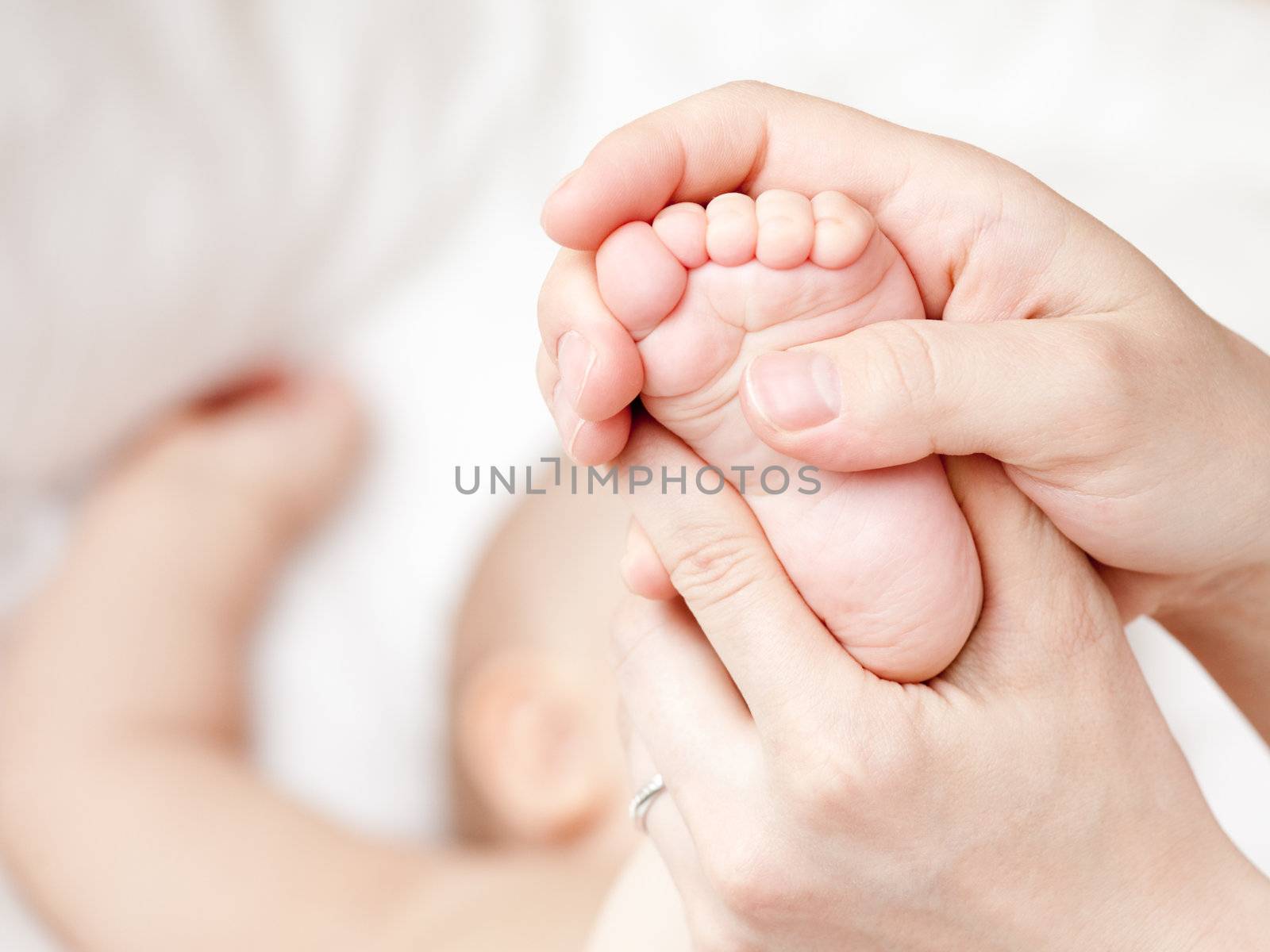 Mother massaging her child's foot, shallow focus