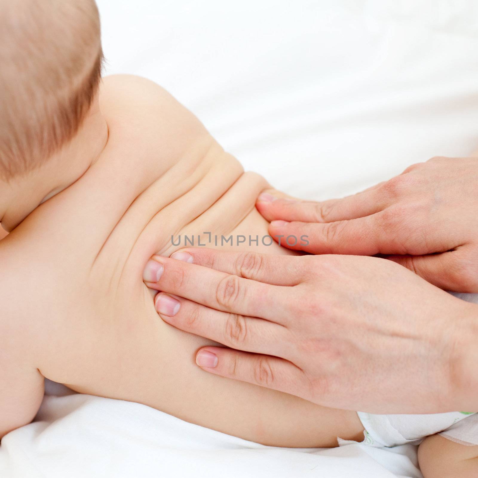 Masseuse massaging little baby girl, shallow focus