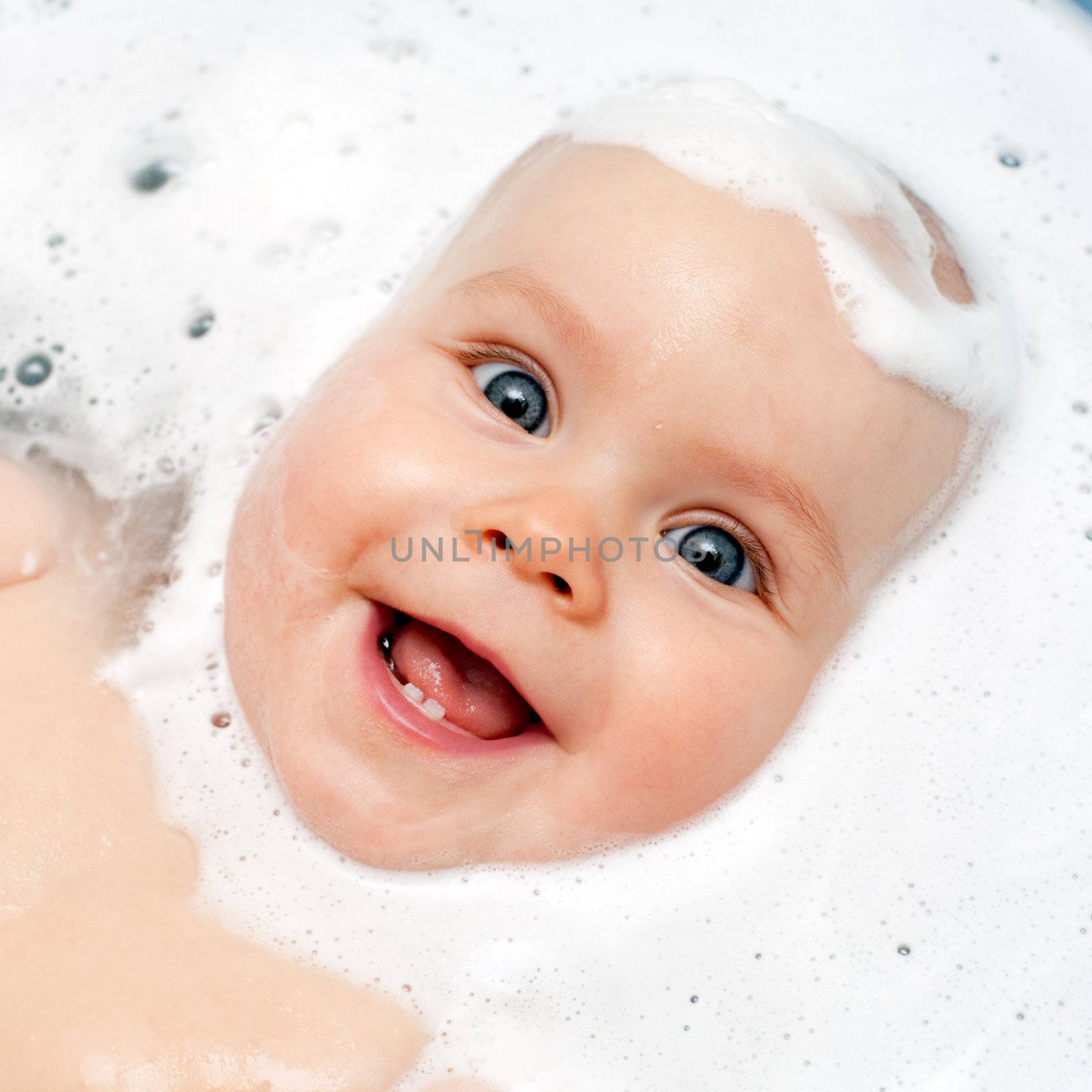 Little baby girl bathing in soapsuds