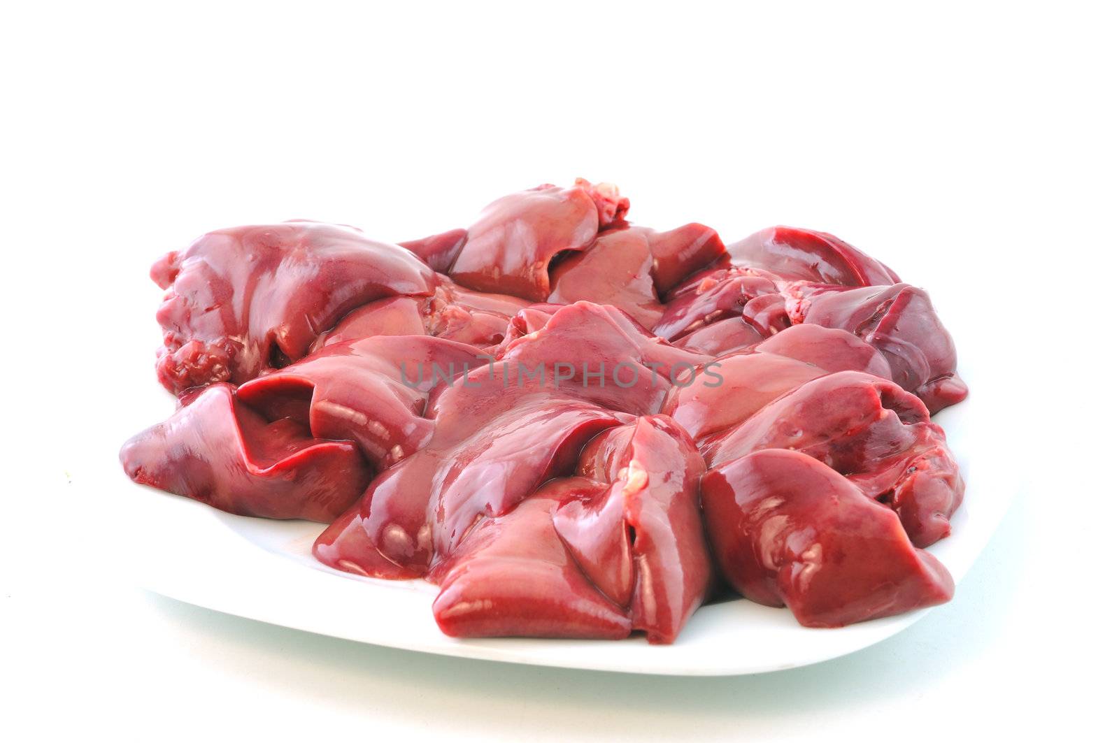 Fresh raw chicken liver lies on the plate against a white background