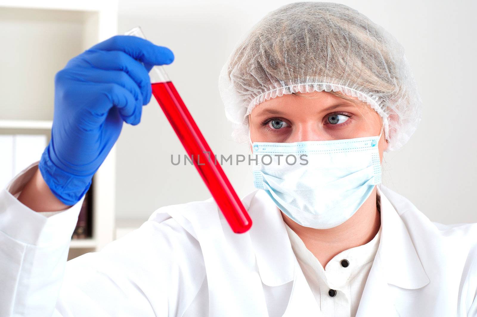 female chemist mixing liquids in test tubes, working in lab