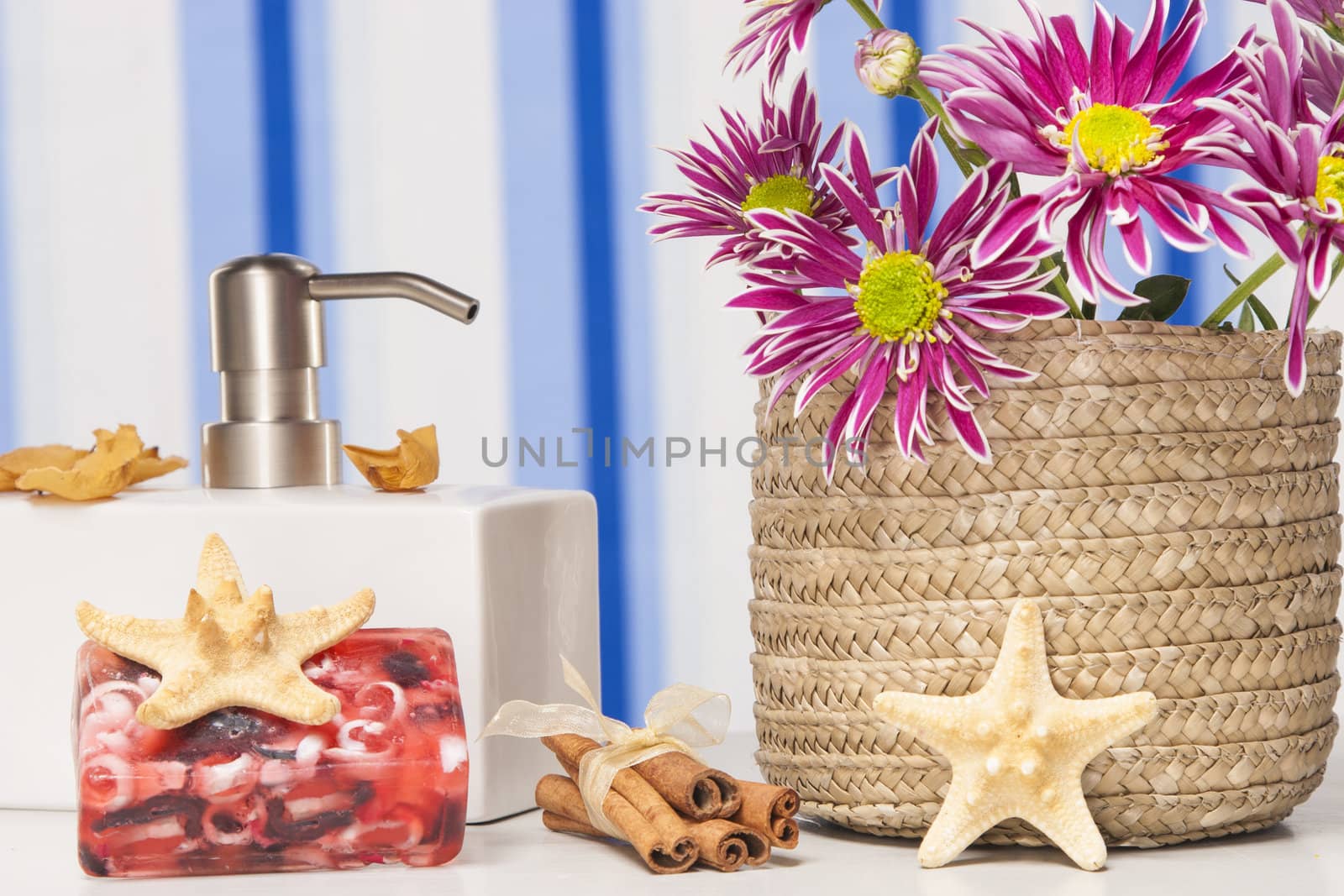 Spa setting with natural soaps and flower on blue strips background