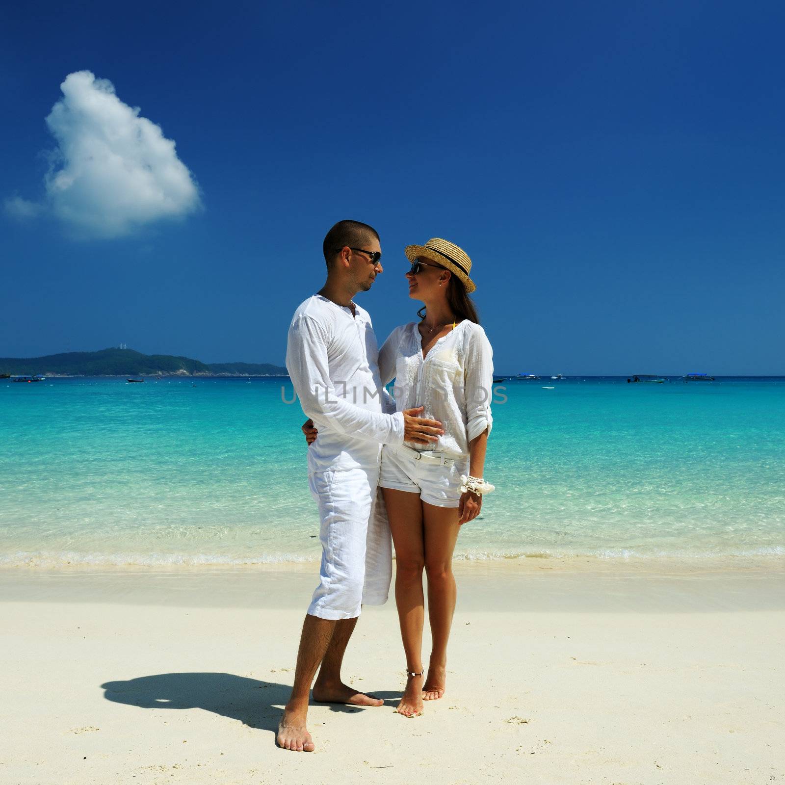 Couple in white on a beach by haveseen