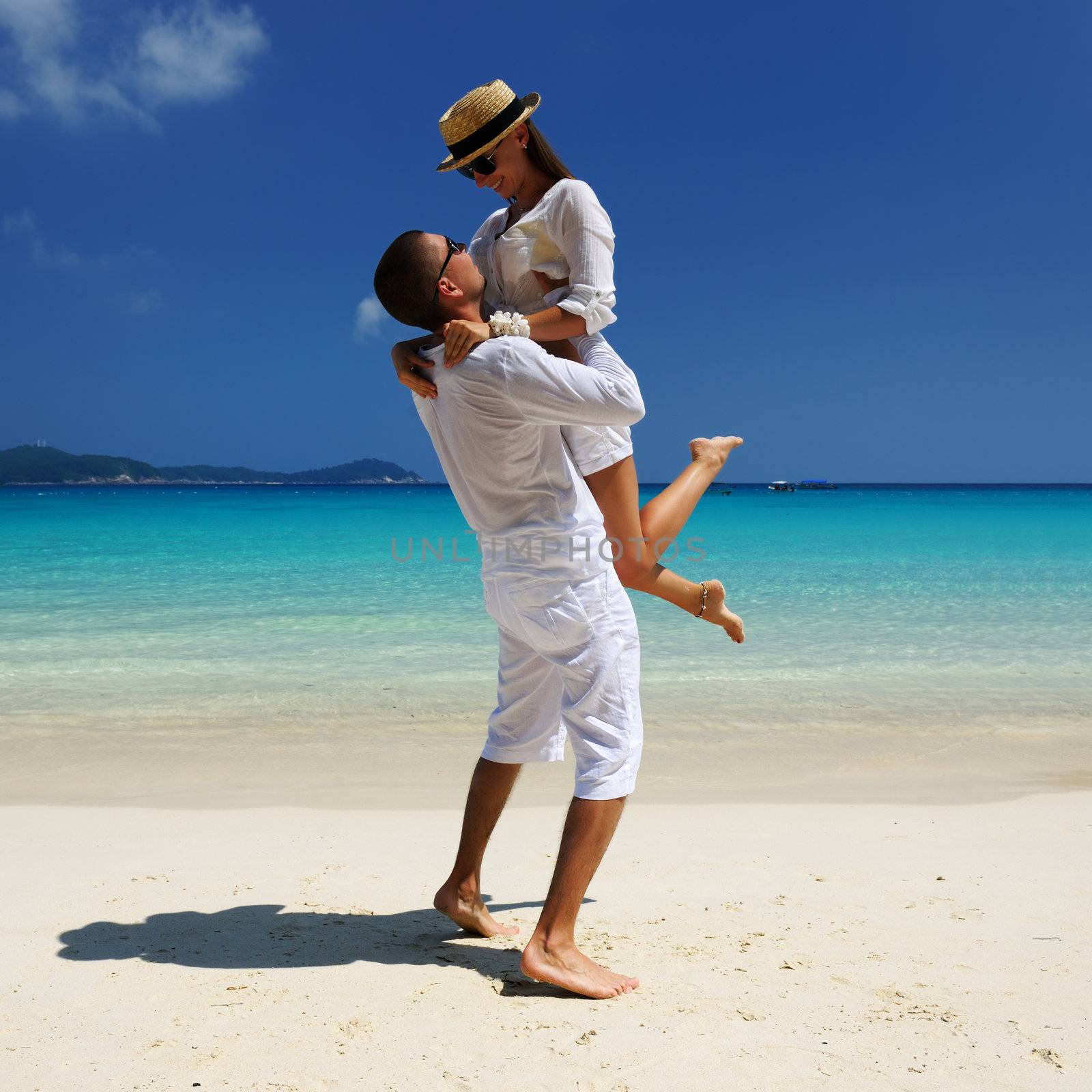 Couple in white on a beach by haveseen