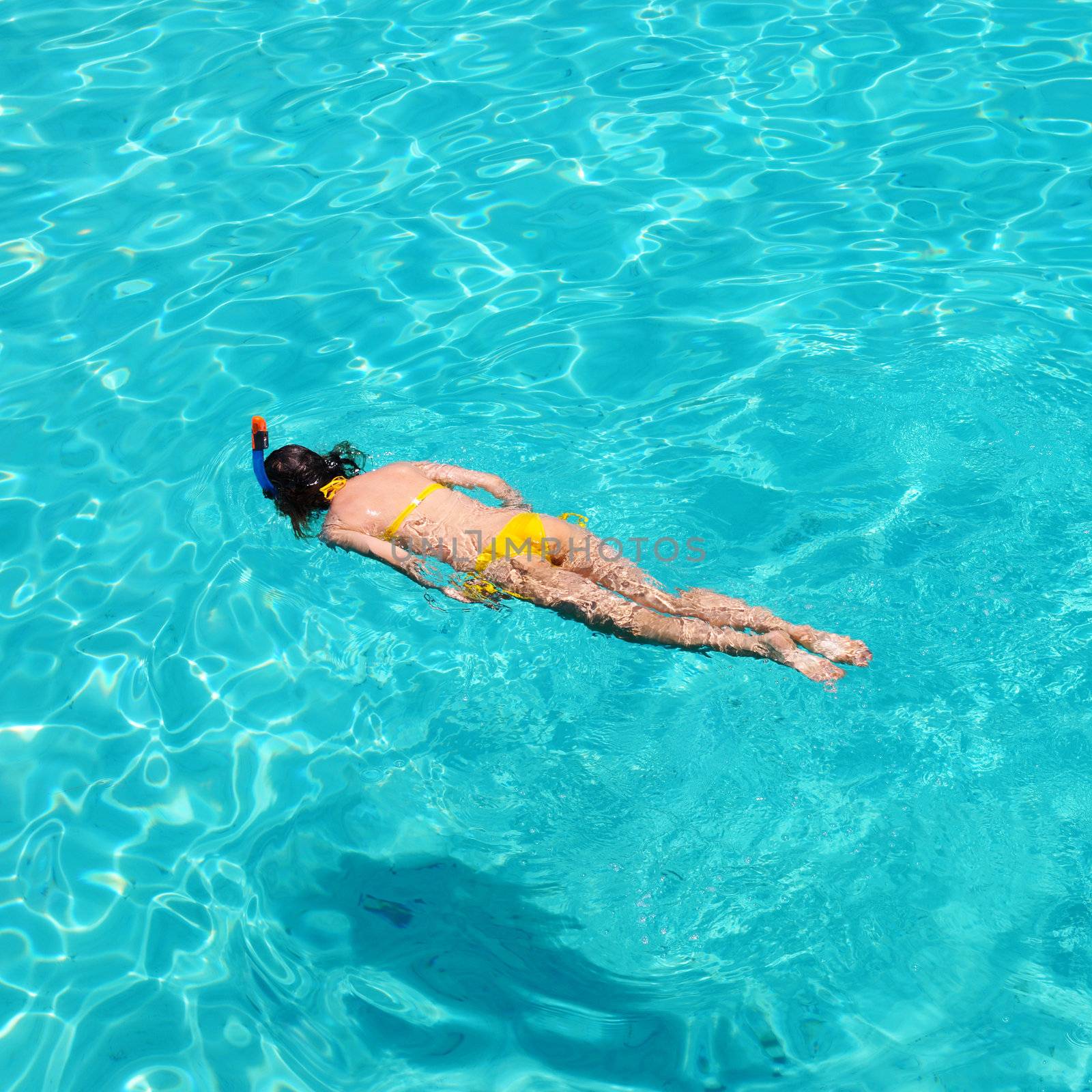 Woman snorkeling in crystal clear turquoise water at tropical beach