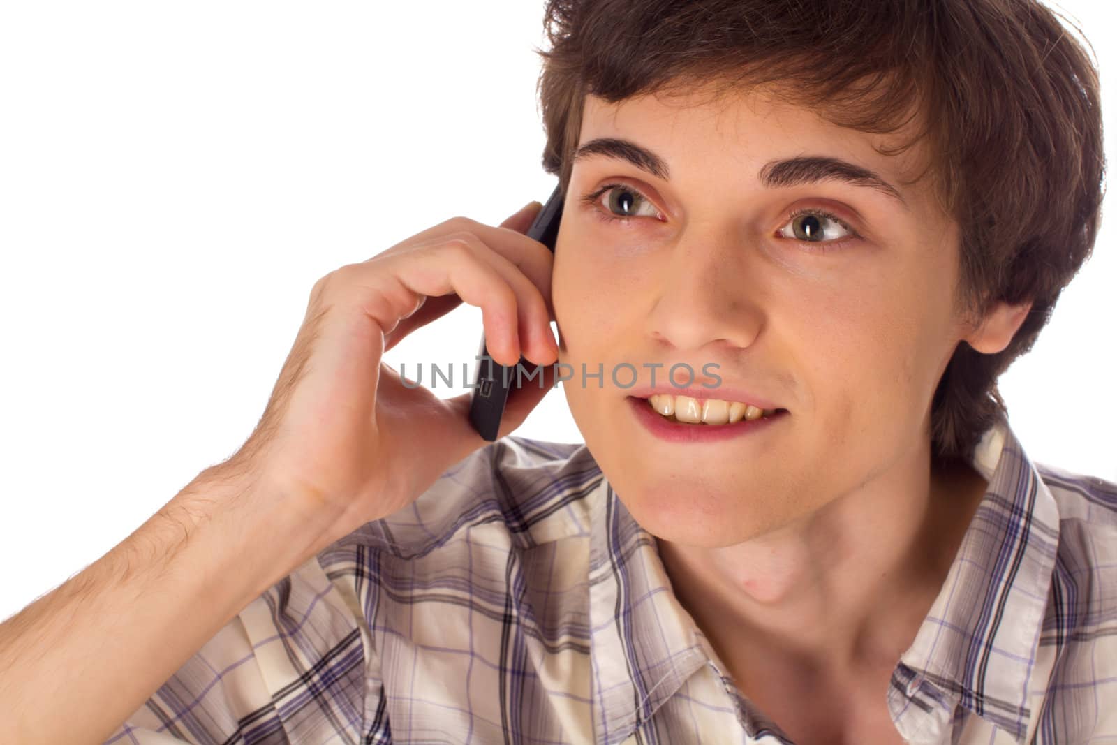 Young male enjoys phone conversation on white background