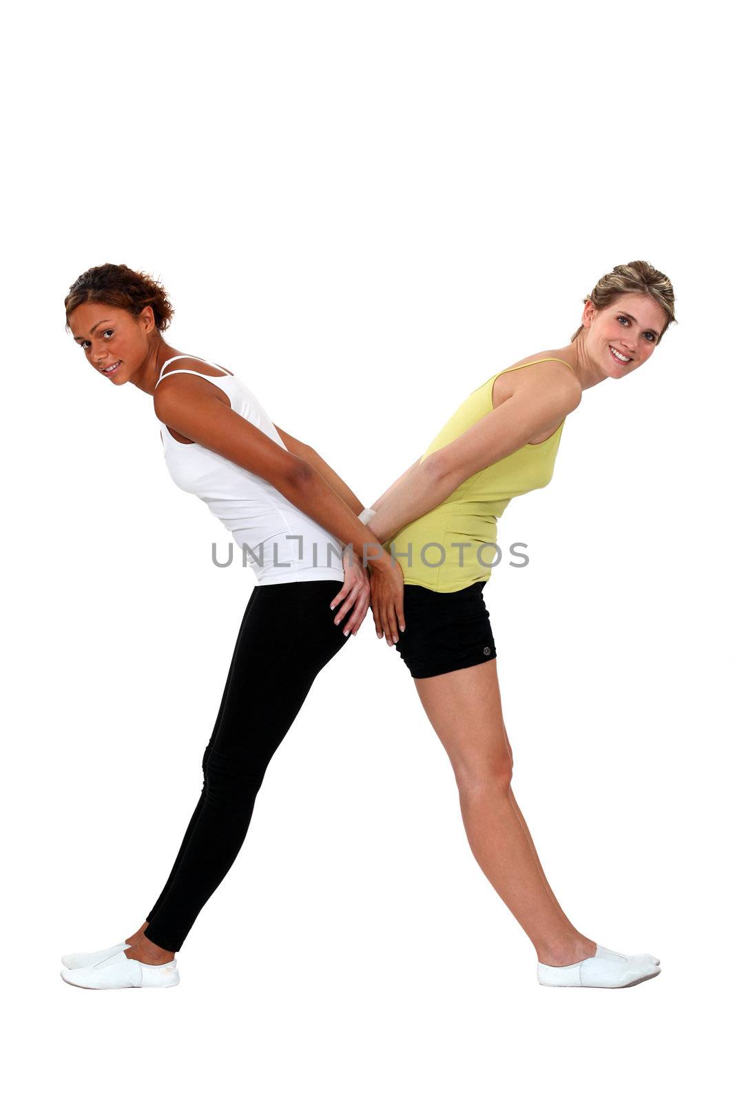 Two women in gym clothing forming the letter X by phovoir