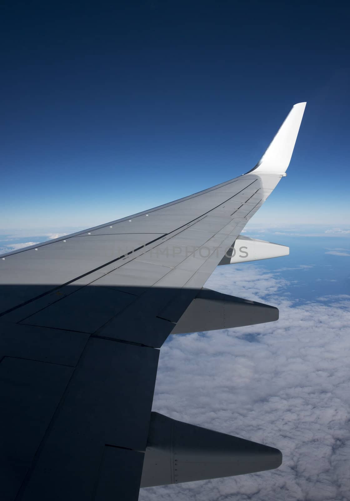 airplane wing with blue sky as background
