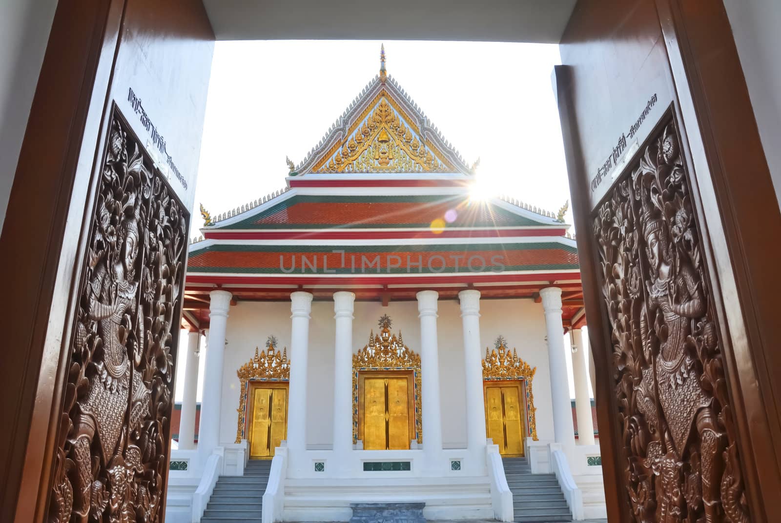 Carved wooden door open to Magut  temple, Bangkok Thailand