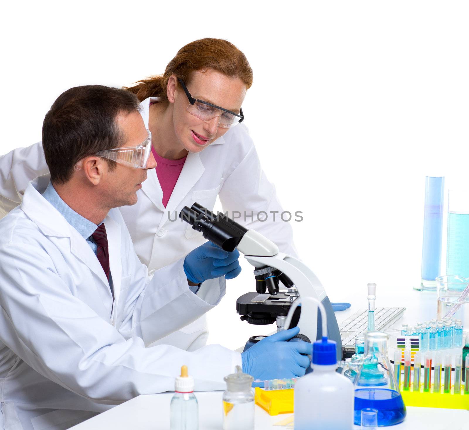 chemical laboratory with two scientist working with test tubes and microscope