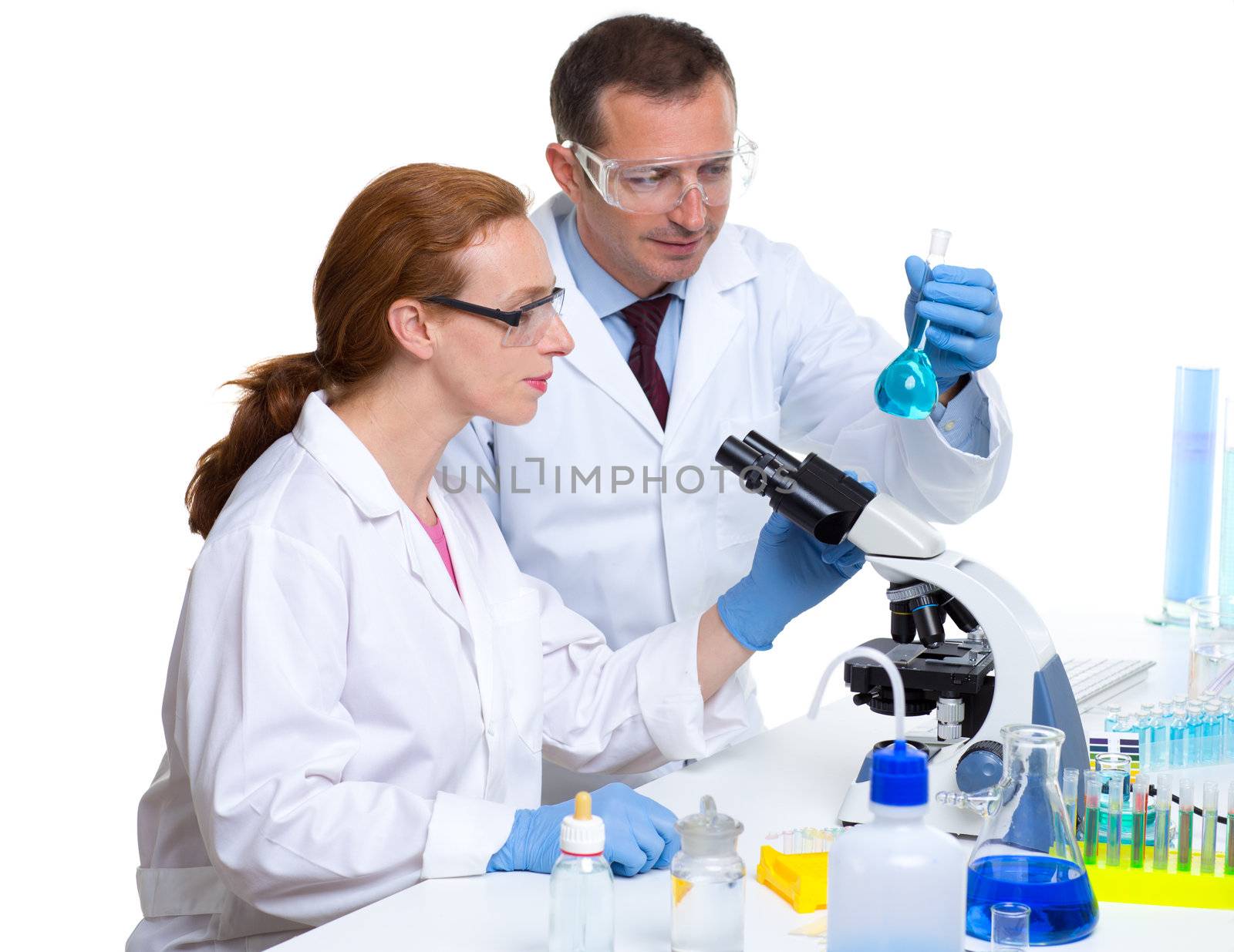 chemical laboratory with two scientist working with test tubes and microscope