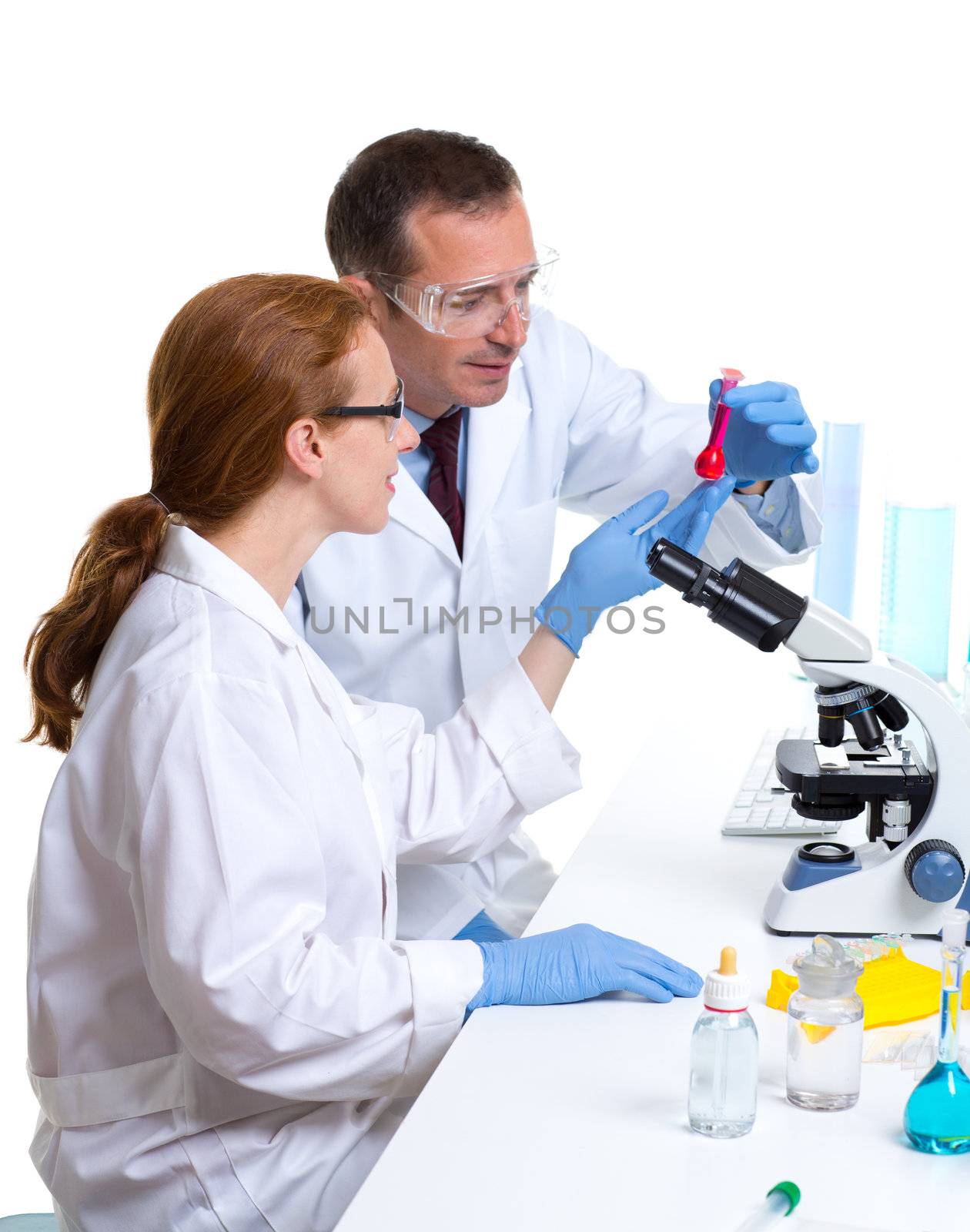 chemical laboratory with two scientist working with test tubes and microscope