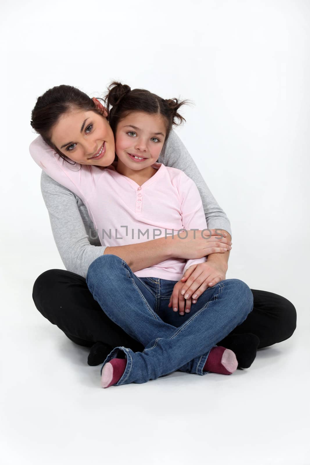 A mother and her daughter hugging. by phovoir