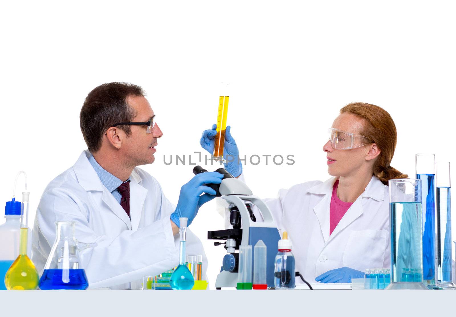 chemical laboratory with two scientist working with test tubes and microscope
