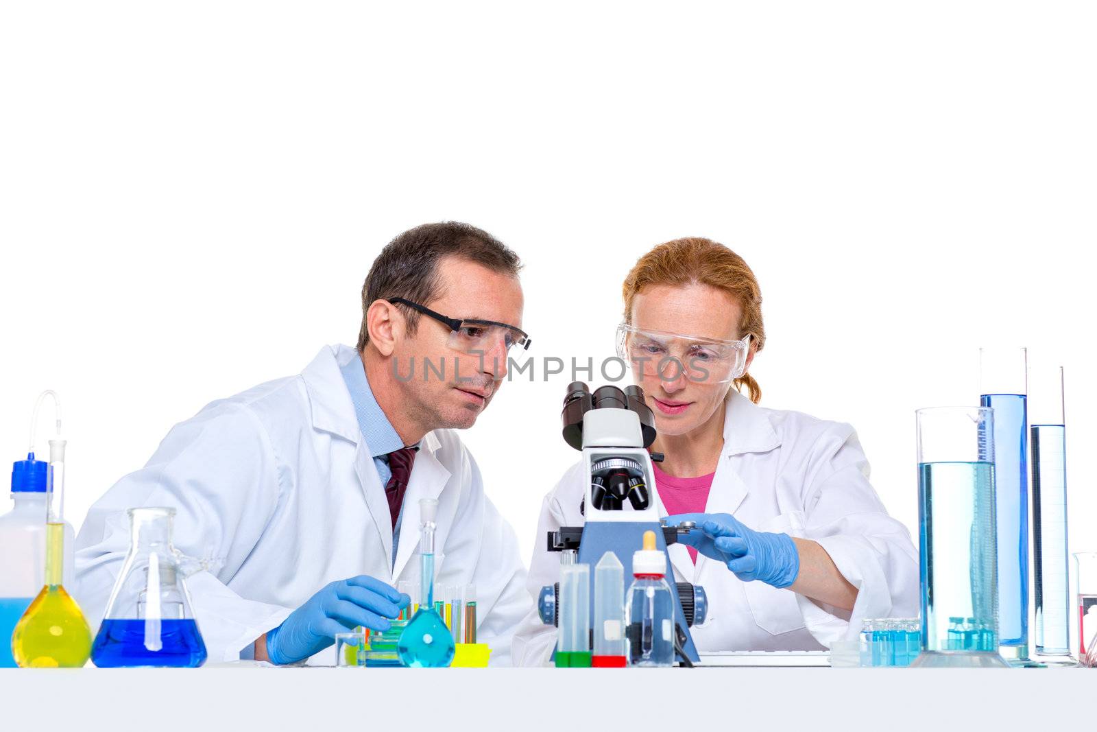 laboratory with two scientist working with test tubes flask and microscope