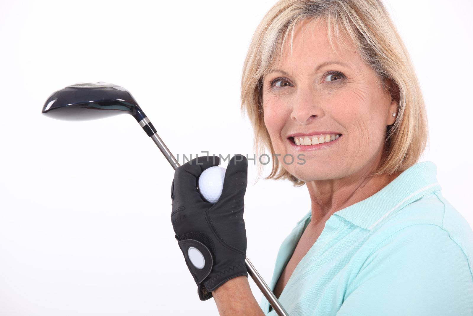 mature blonde woman taking golf club and golf ball