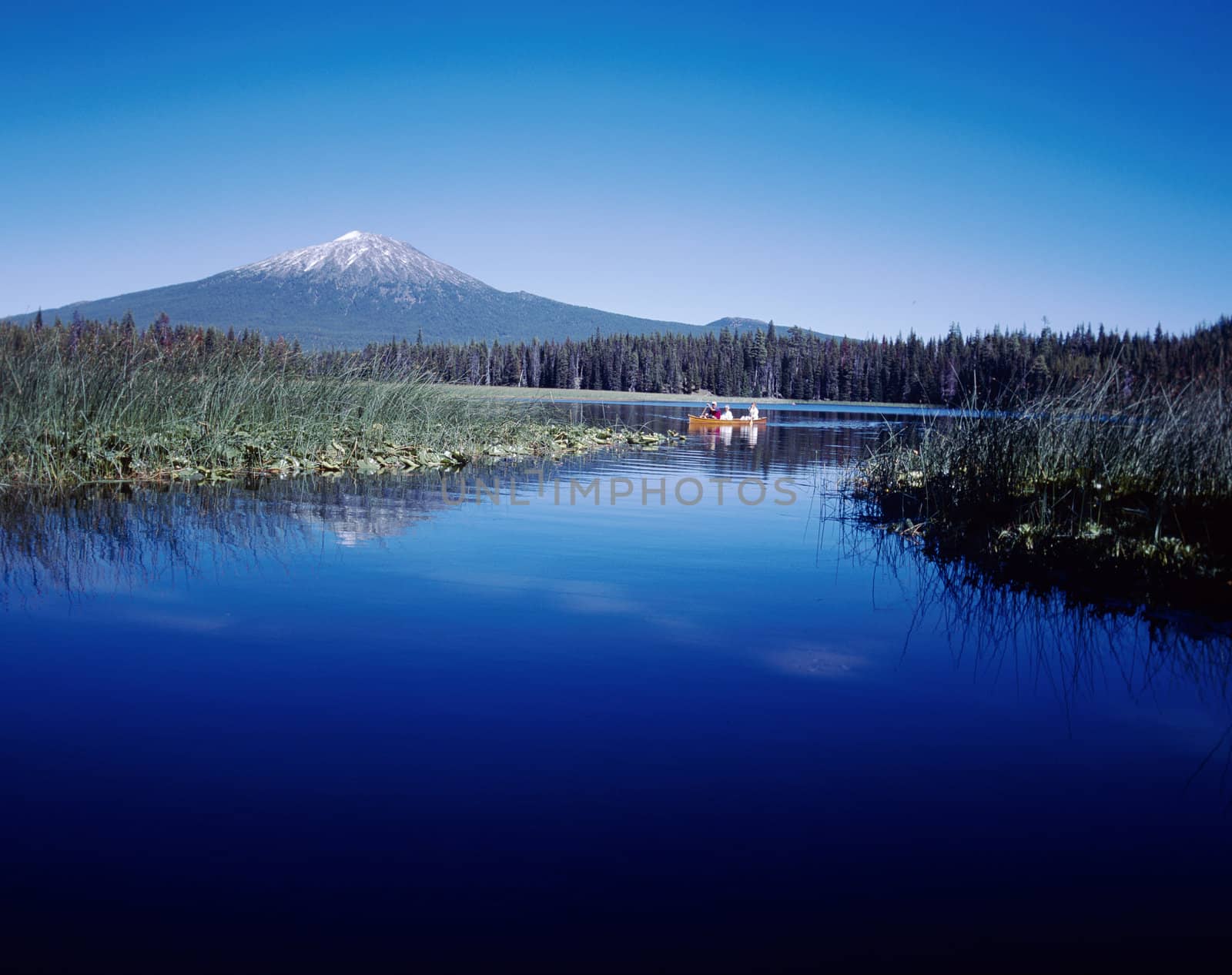 Majestic mountain in Cascades range in Oregon reflected in deep blue lake