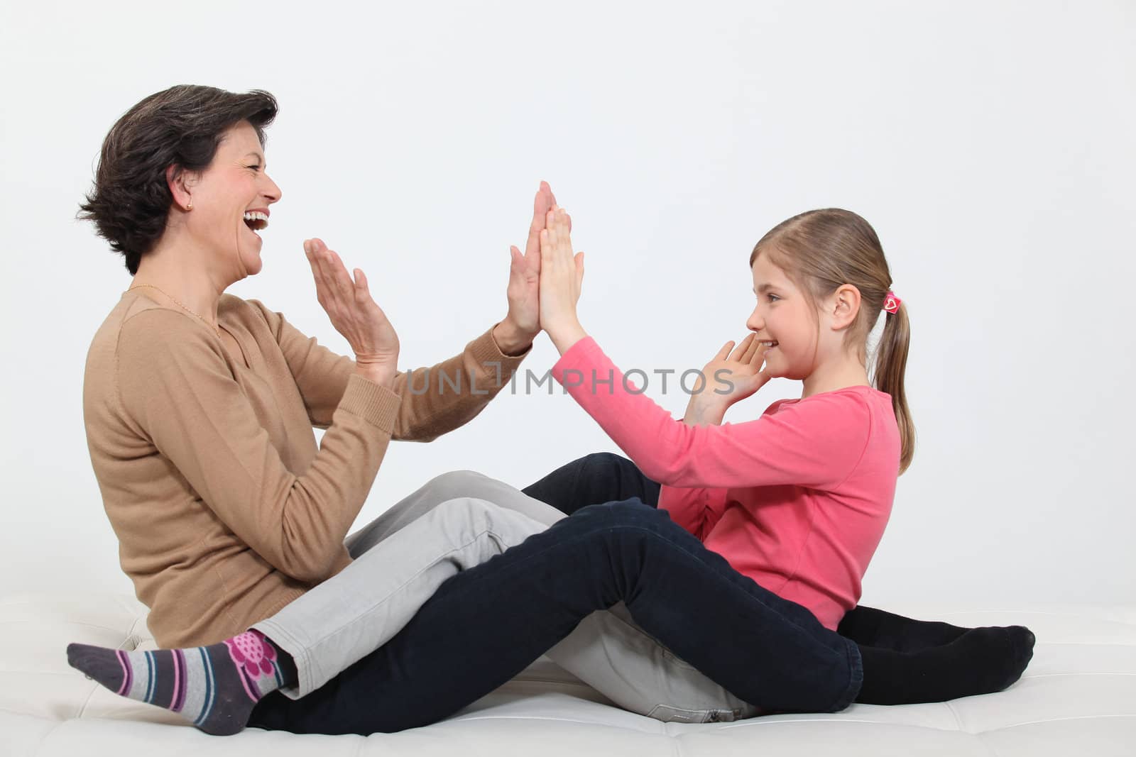 Woman and girl clapping hands by phovoir