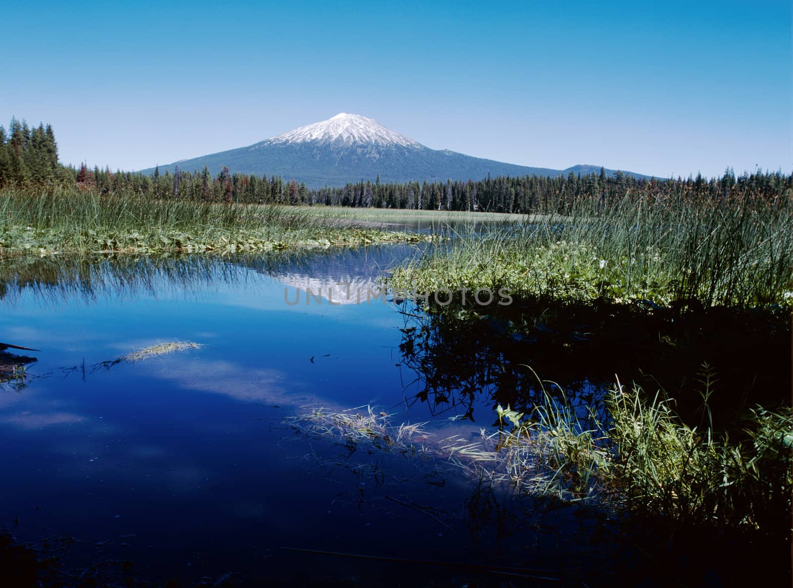 Majestic mountain in Cascades range in Oregon reflected in deep blue lake