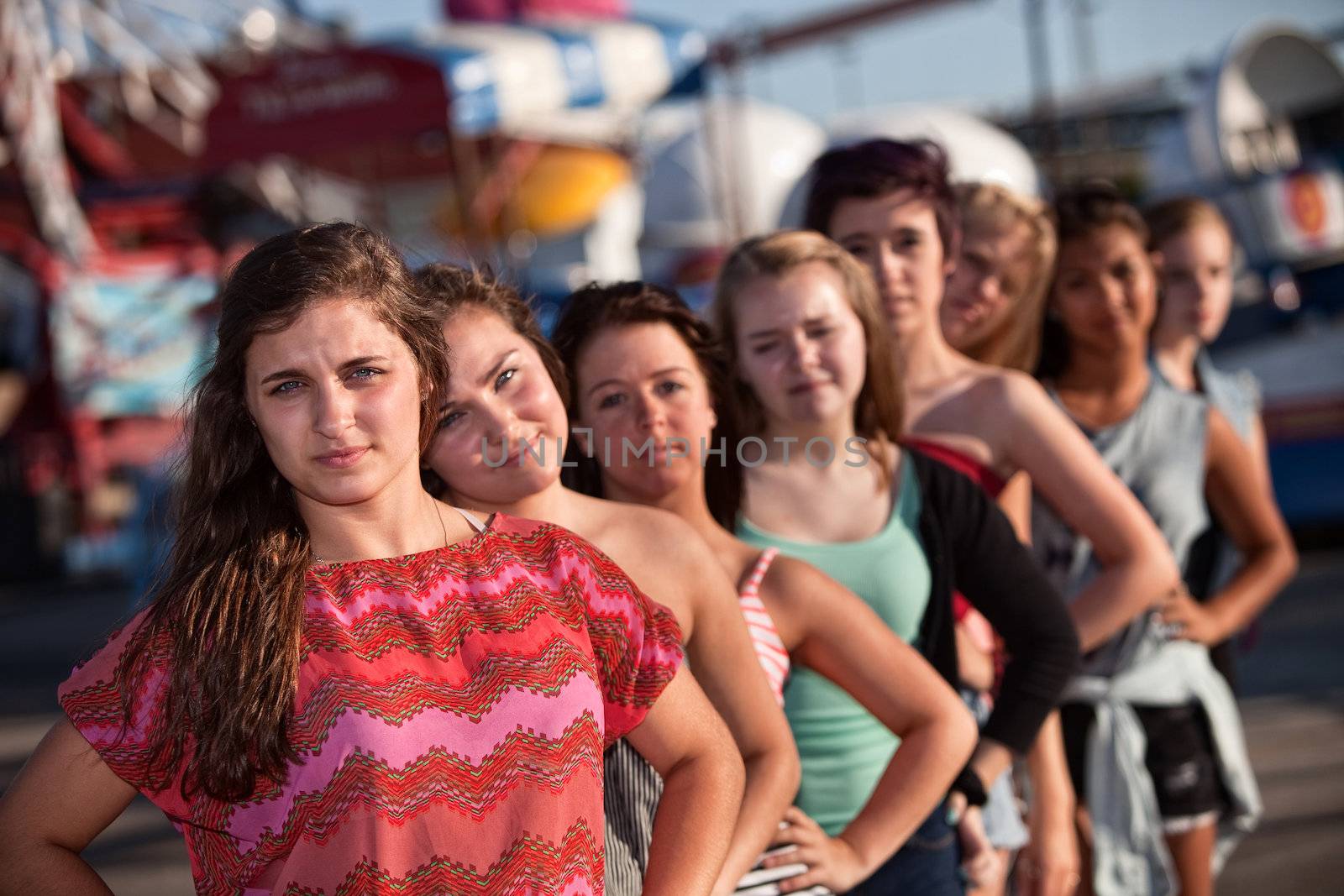 Serious teenage girl with group of friends outdoors