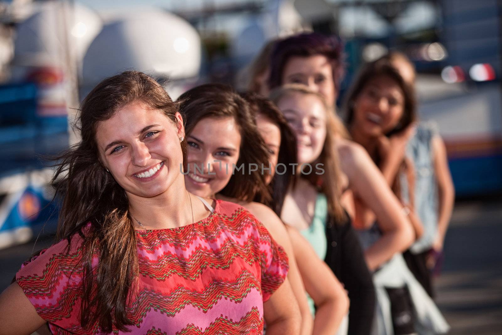 Confident female teenager with group of friends outdoors