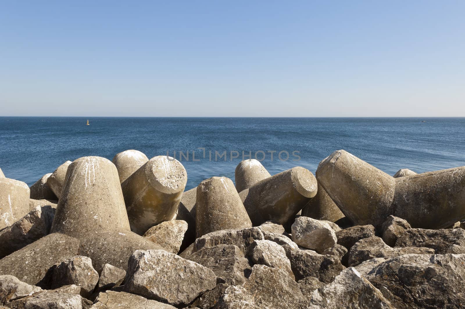 Concrete tetrapod  breakwater in the shore near Sesimbra, Portugal