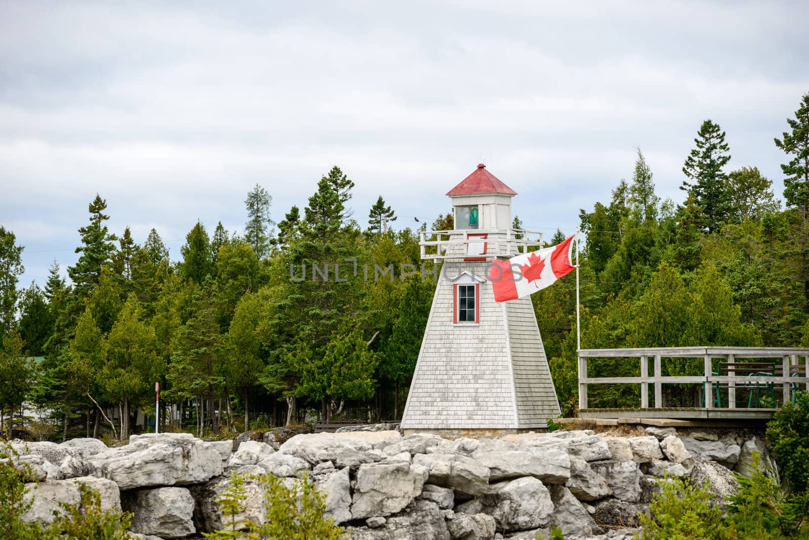 Built in 1898, the South Baymouth range lights rest along a shore reinforced with a low stone wall along the water's edge plus a second, taller wall a few yards back. The lights are nearly identical: white, wood towers angling upward to support square, wooden walkways and lanterns with red caps. Both are marked with a long, red stripe running nearly the height of their front walls to provide day markers for ships approaching the area. The 17 foot tall front range stands close to the water, and the 26-foot-tall rear range is about 250 yards inland, nearly hidden by tall trees.