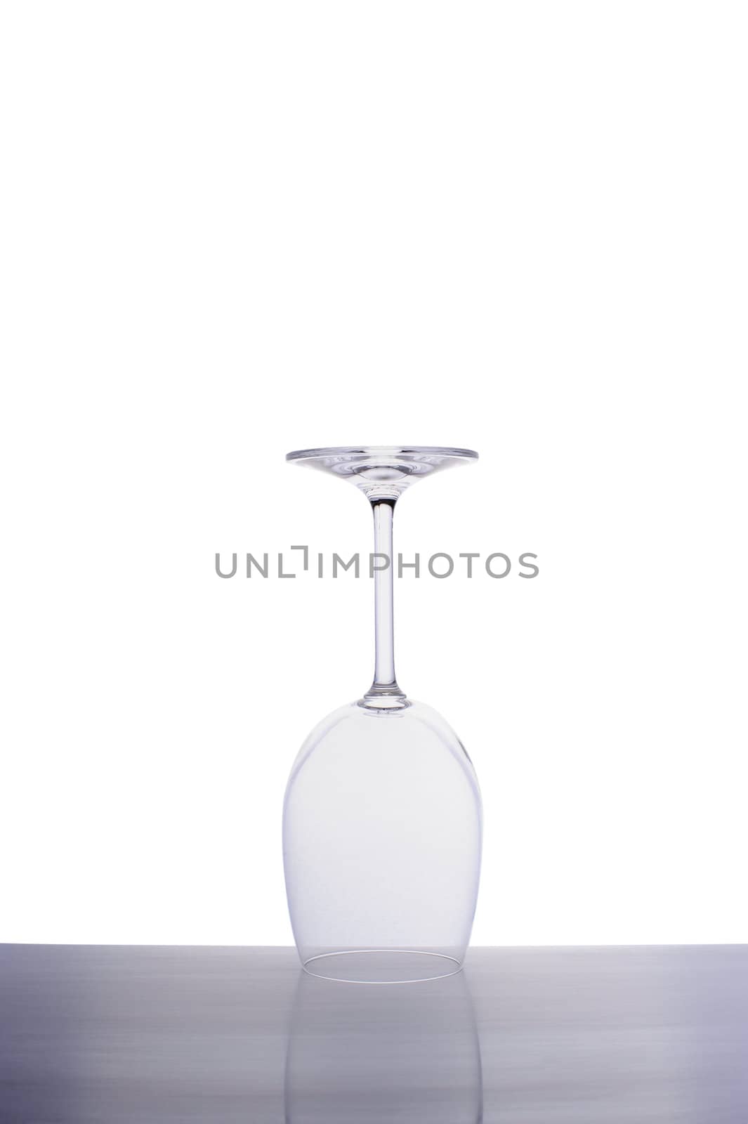 Inverted empty wine glass isolated on white background