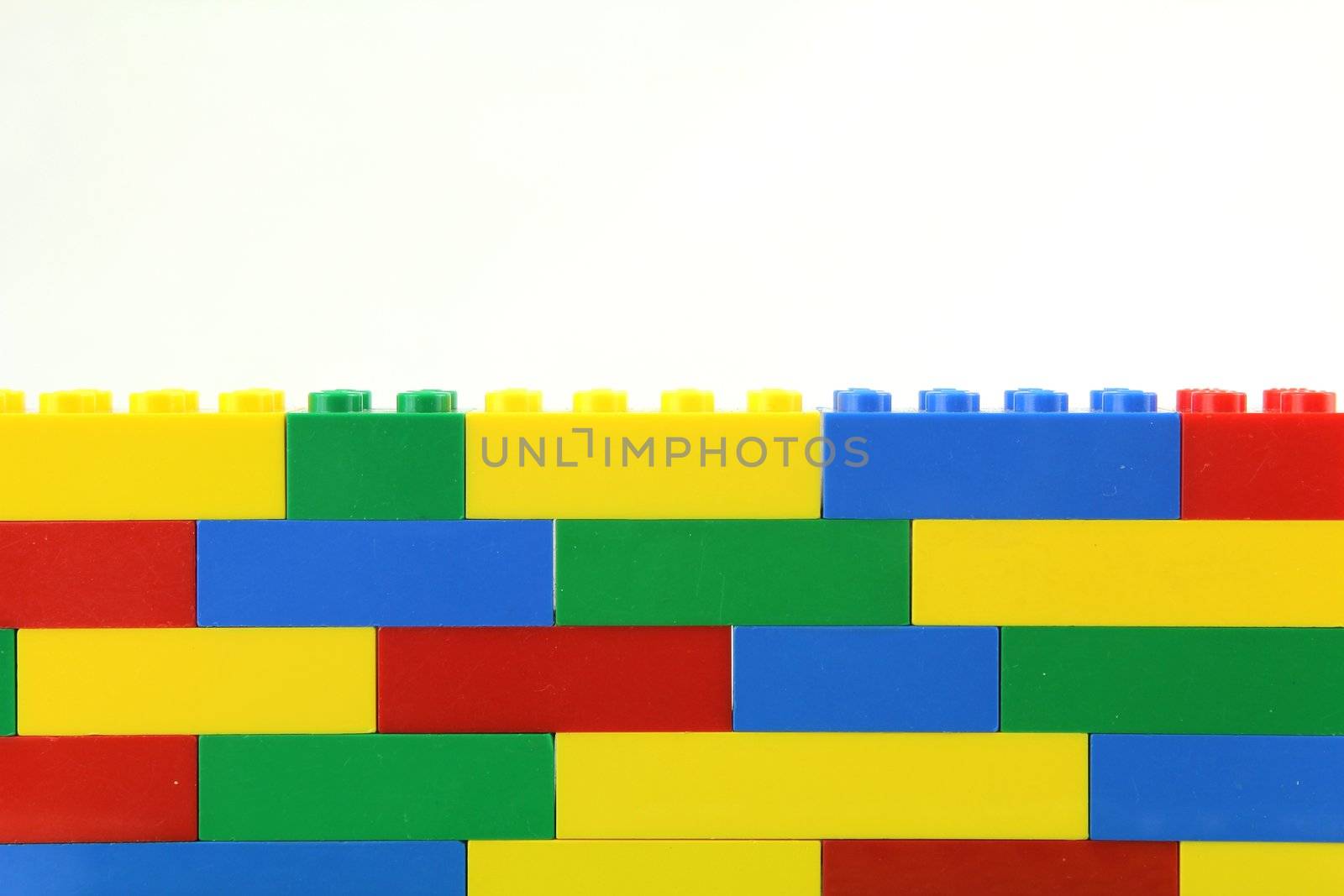 Multi coloured lego wall on white background