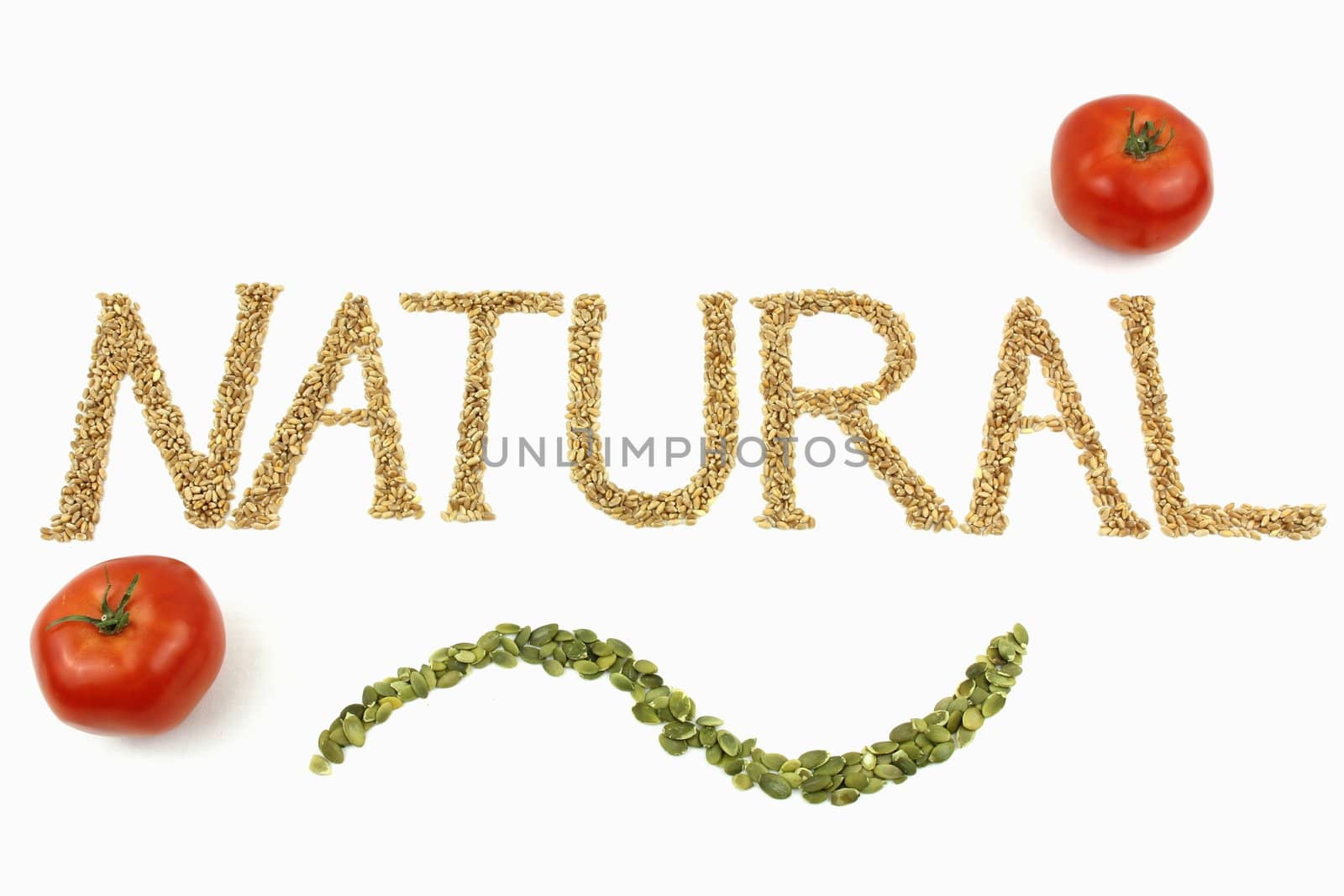 Natural written with wheat kernels, tomatoes and pumpkin seeds on white background
