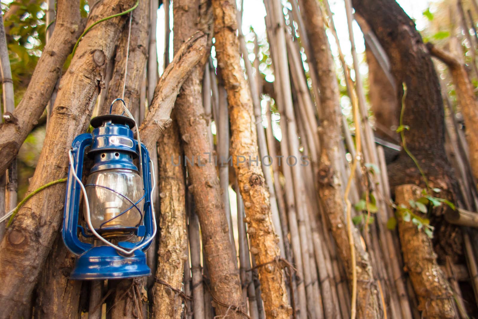 Oil lantern hanging against stick wall in African village