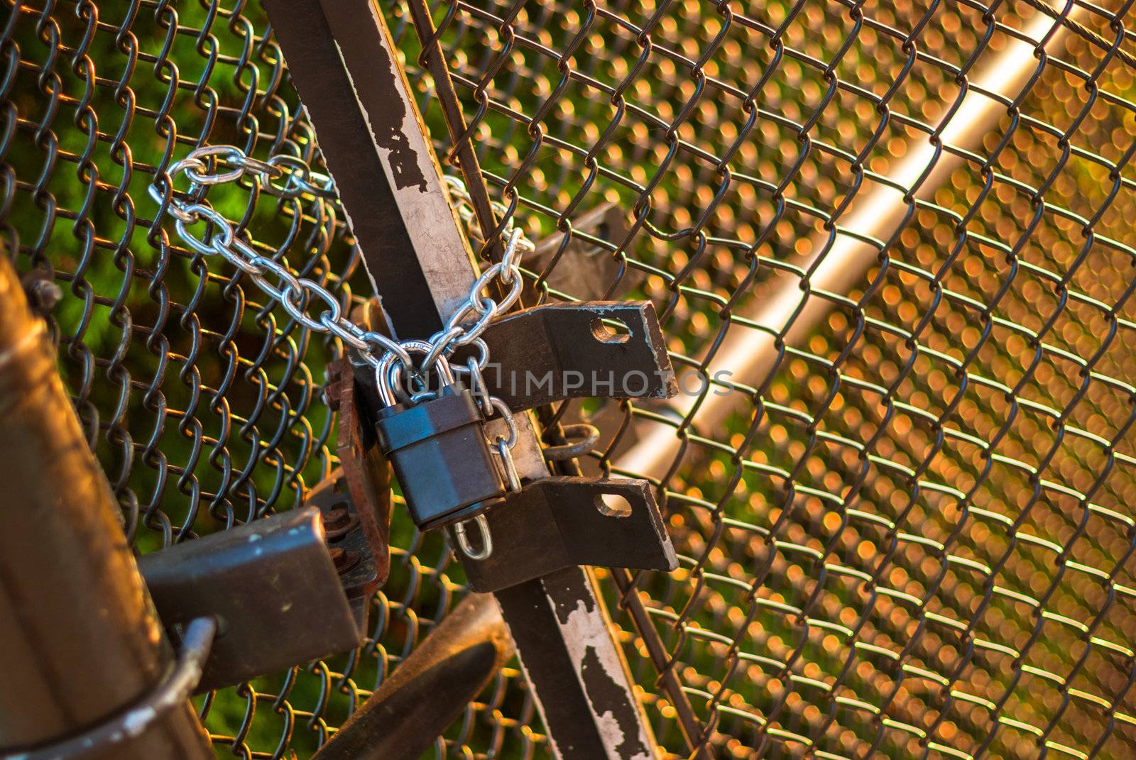Padlock and chain holding wire fence gate closed