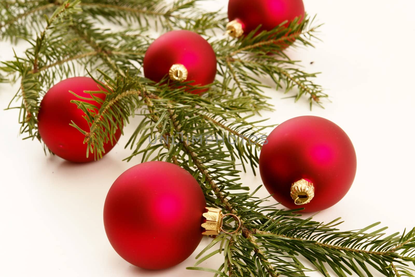 Border of red christmas garland with baubles and ribbons on white.