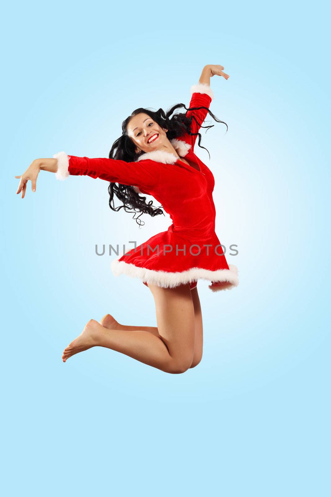 Happy smiling woman in red xmas costume jumping high